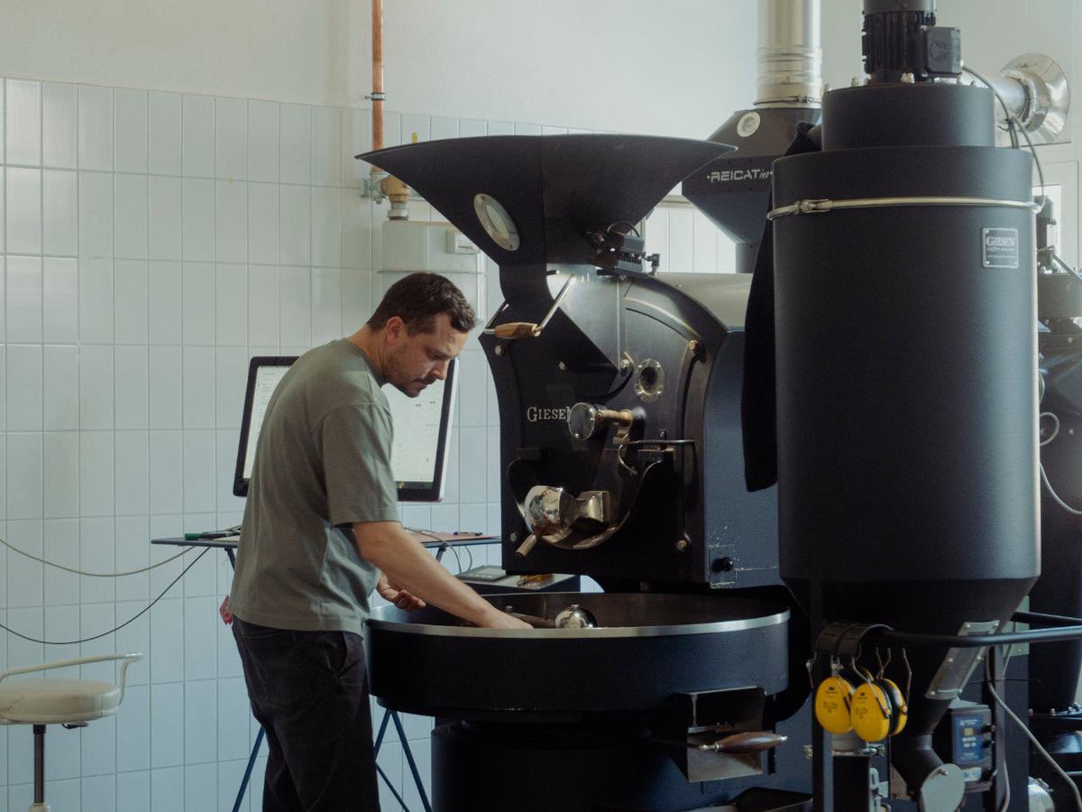 Philip an der Röstmaschine Giesen W15. Titelbild des Blogbeitrags.